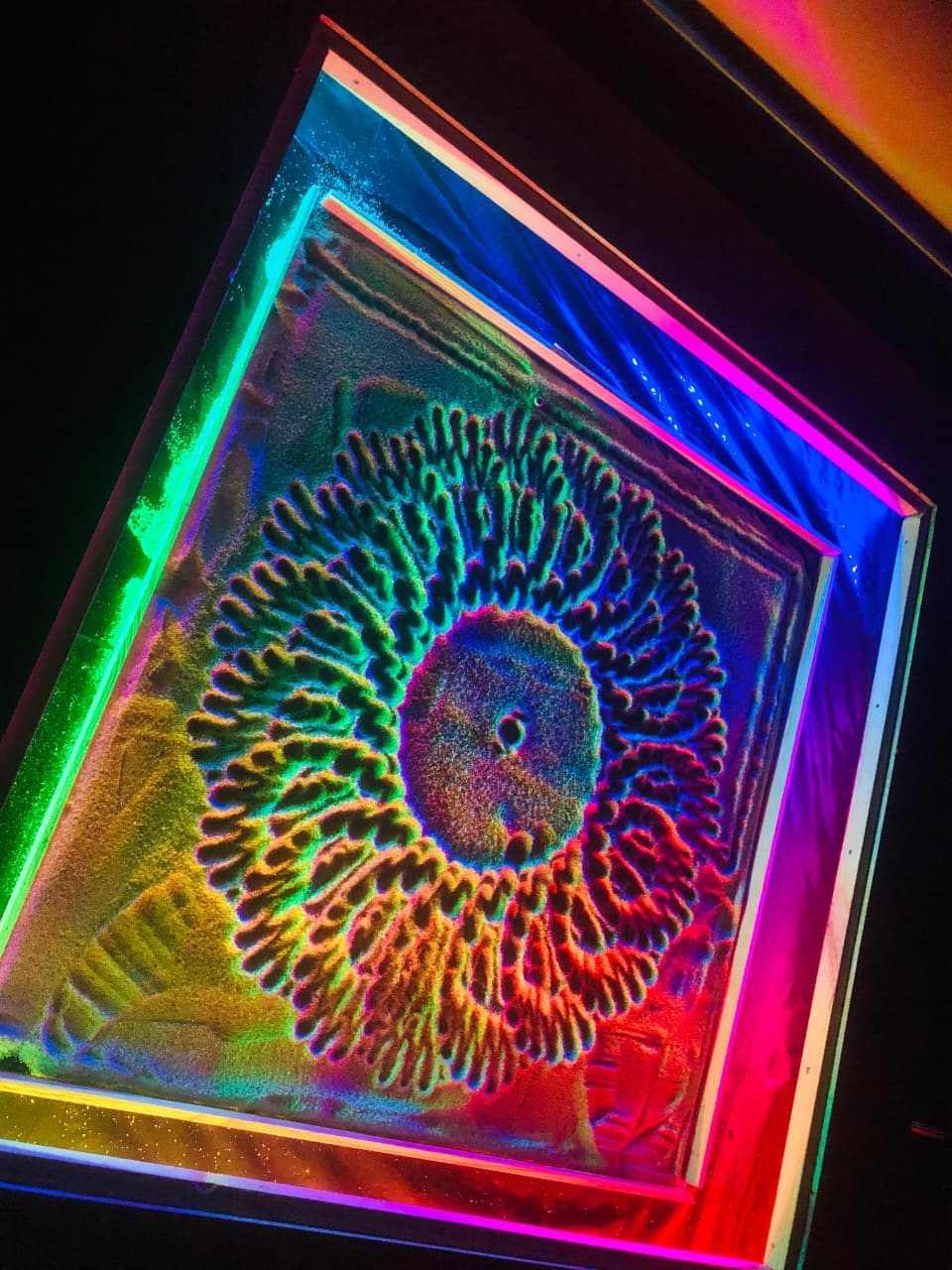 Multi-spectrum RGB lighting across circular sunflower sand sculpture