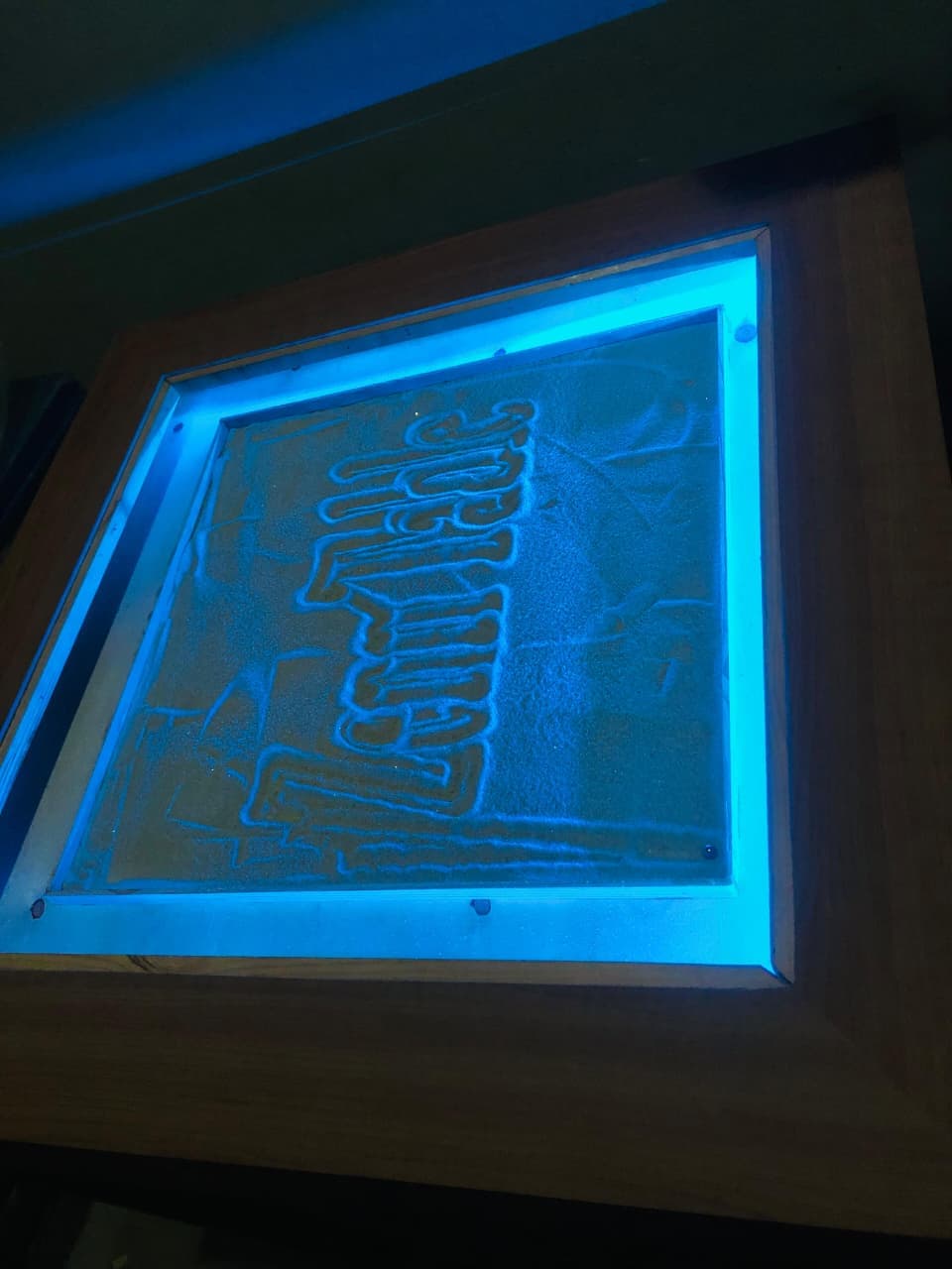 Custom typography 'Zen Table' carved into sand surface